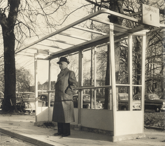 603450 Afbeelding van een wachtende man bij een nieuw type abri (maar nog zonder glas) bij een bushalte van lijn 1 aan ...